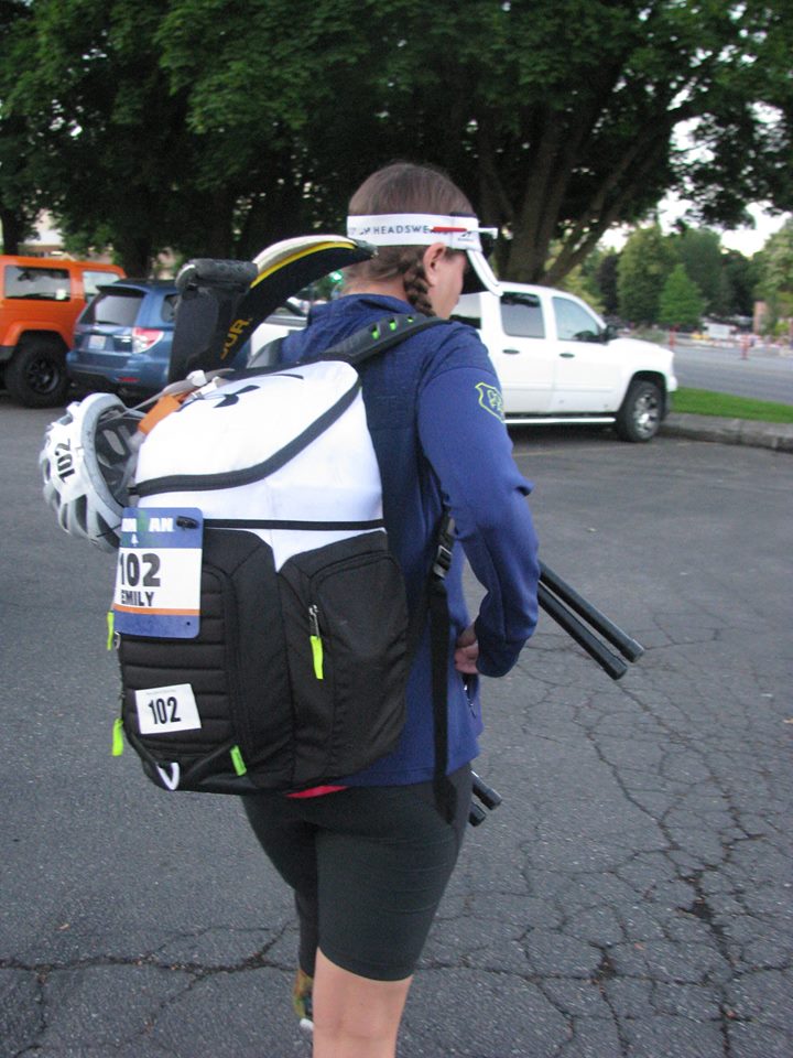emily walking away from the camera wearing her transition bag with legs sticking out the top