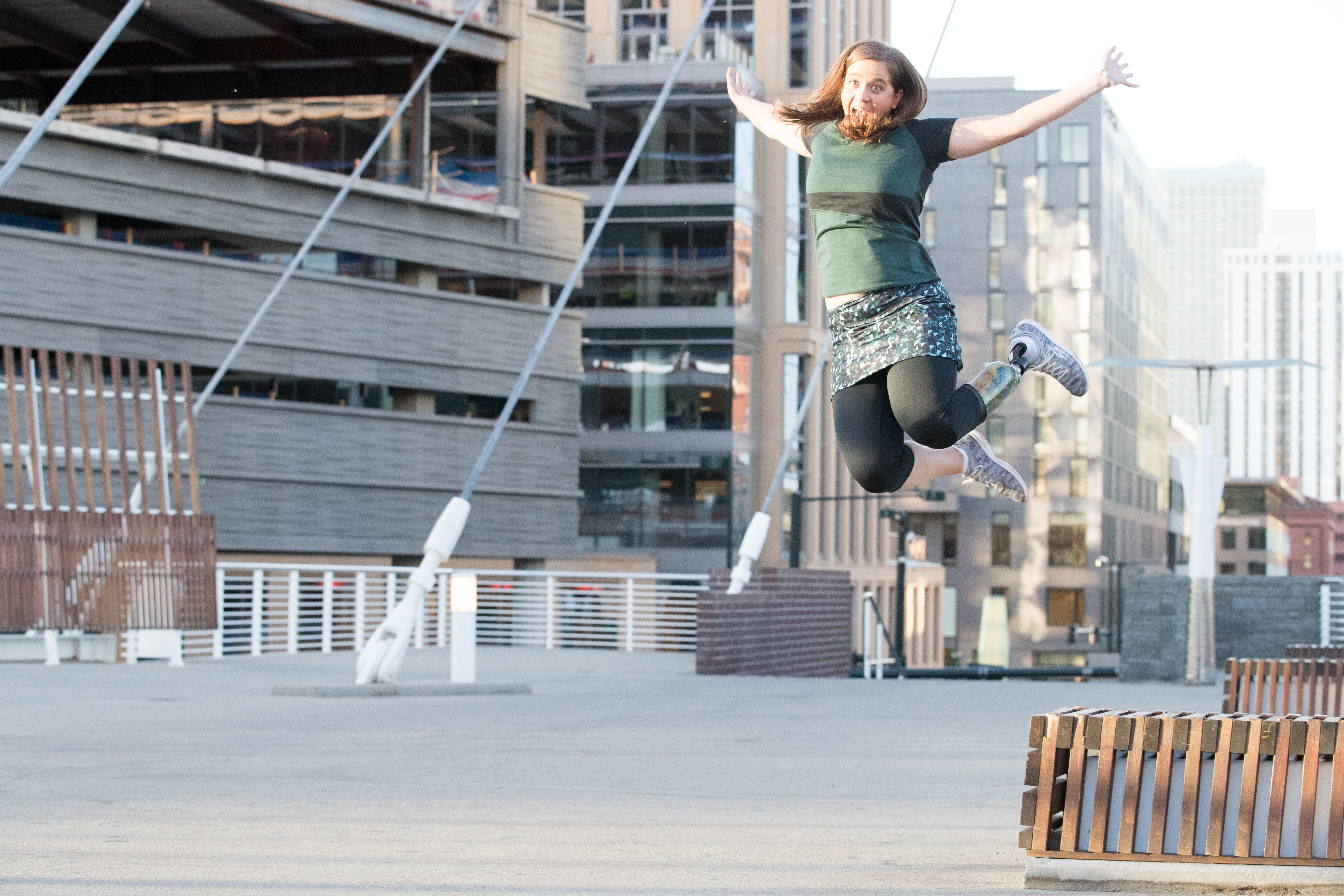 Emily jumping off a bench decked out in Skirts Sports gear at a photo shoot for Skirt Sports. Photo credit: Kim Cook