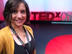 Me after hair and makeup standing in front of the TEDx letters